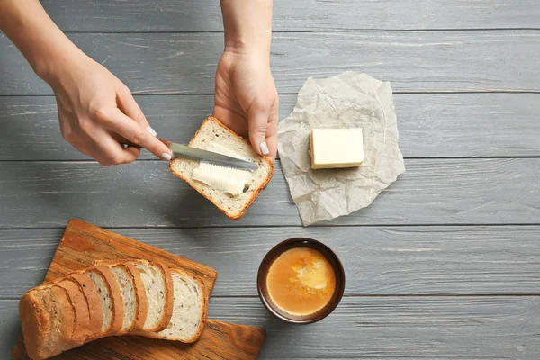 Tangan wanita dengan roti bakar dan mentega — Stok Foto