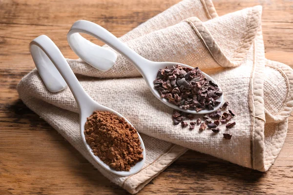 Skedar med kakao nibs och pulver — Stockfoto