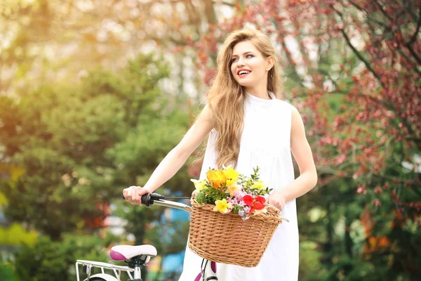 Leende kvinna som står nära cykel — Stockfoto