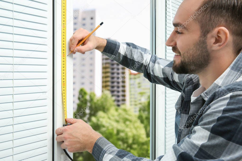 Man taking measure of window 