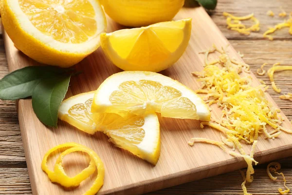 Tabla con limones cortados y ralladura —  Fotos de Stock