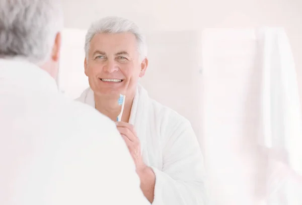 Senior man reinigen van tanden — Stockfoto