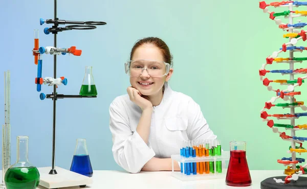 Щаслива школярка сидить на робочому місці в хімічному класі — стокове фото