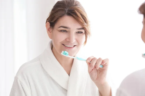 Mujer mayor limpiando dientes — Foto de Stock