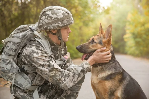 Soldado com cão de trabalho militar em fundo desfocado — Fotografia de Stock