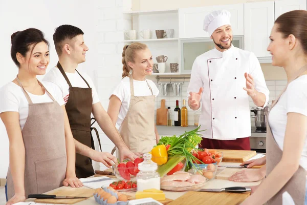 Chefe masculino e grupo de pessoas em aulas de culinária — Fotografia de Stock