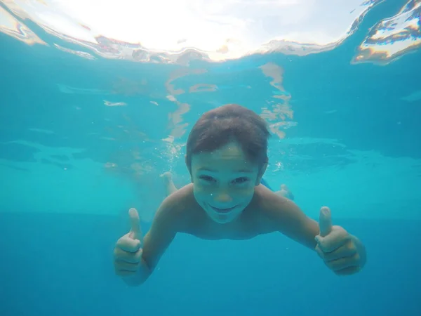 Kleiner Junge schwimmt unter Wasser in Pool — Stockfoto