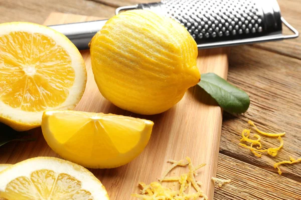 Доска с вырезанными лимонами и цедрой — стоковое фото