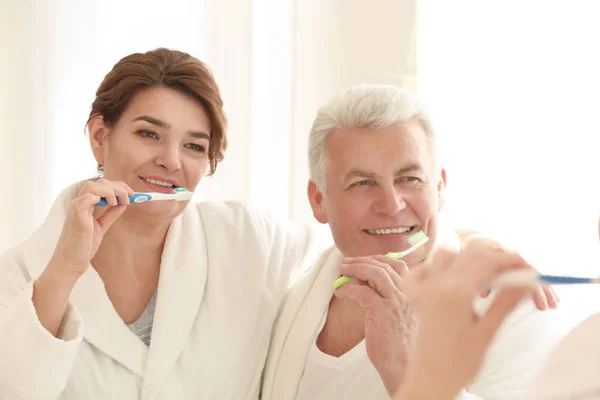 Senior couple cleaning teeth