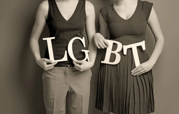 Casal lésbico segurando cartas LGBT — Fotografia de Stock