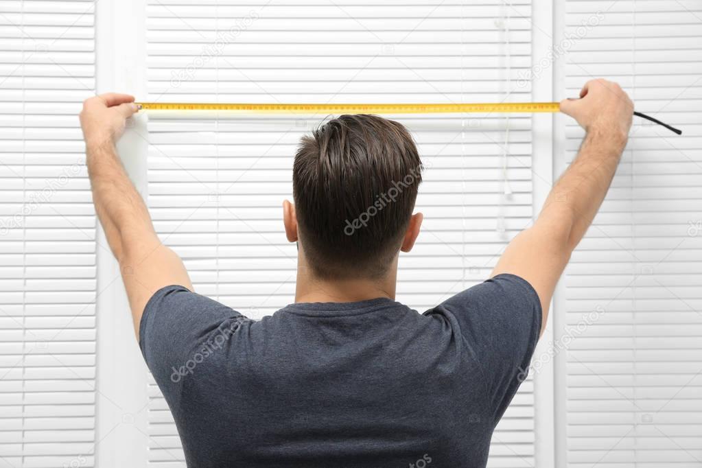 man installing window shades 