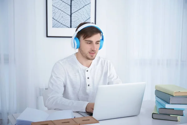 Concept of audiobook. Handsome young man with headphones and book — Stock Photo, Image