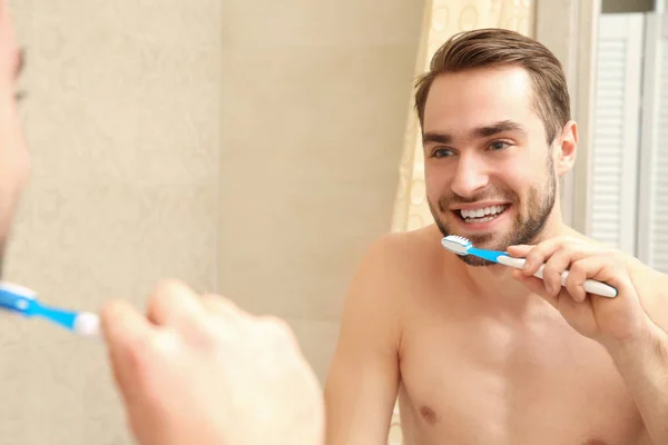 Hombre guapo cepillándose los dientes — Foto de Stock