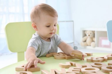 Evde harfleri ile oynayan sevimli küçük çocuk