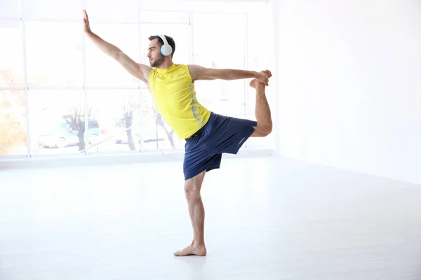 Man doing yoga and listening to music — Stock Photo, Image