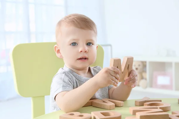 Милый маленький ребенок играет с письмами дома — стоковое фото