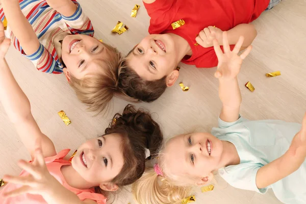 Crianças pequenas bonitos com confete deitado no chão em casa — Fotografia de Stock