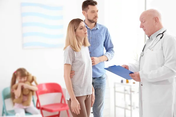 Senior doctor talking to parents — Stock Photo, Image