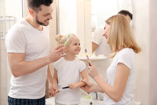 Pareja e hija cepillándose los dientes — Foto de Stock