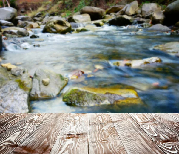 Wooden table and water cascade — Stock Photo, Image