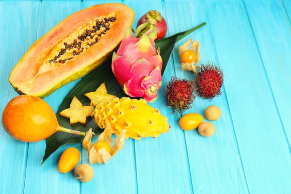 Šťavnaté exotického ovoce na modré dřevěné pozadí — Stock fotografie