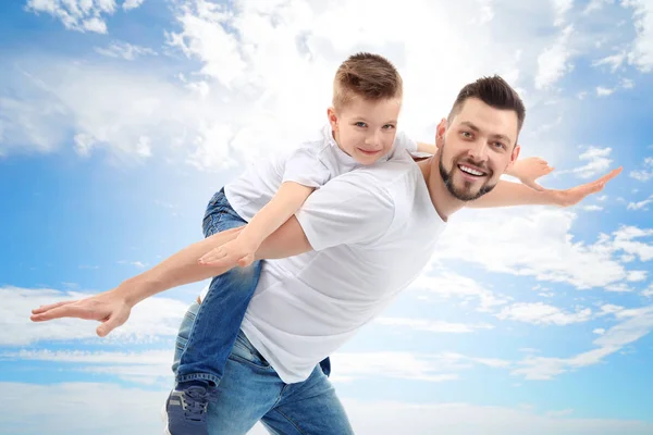 Vader en zoon op blauwe hemel — Stockfoto