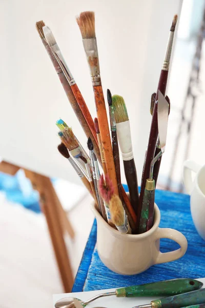 Cup with artist accessories — Stock Photo, Image
