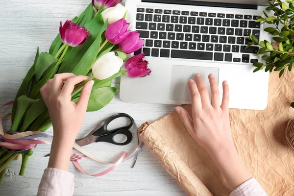 Kobiece Kwiaciarnia z laptopa i kwiaty — Zdjęcie stockowe