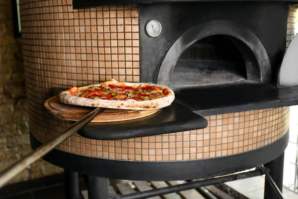 Gebackene Pizza in der Nähe des Ofens — Stockfoto