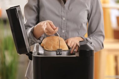 Ekmek makinesi tutan kadın