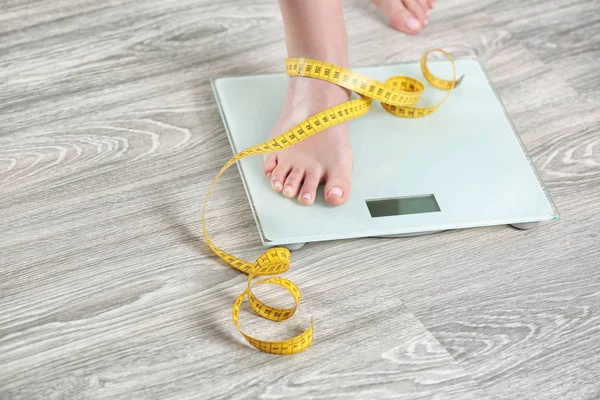 Woman standing on scales — Stock Photo, Image