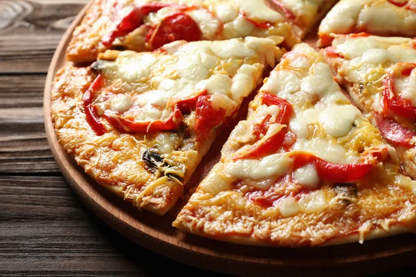 Sabrosa pizza casera en rodajas sobre mesa de madera —  Fotos de Stock