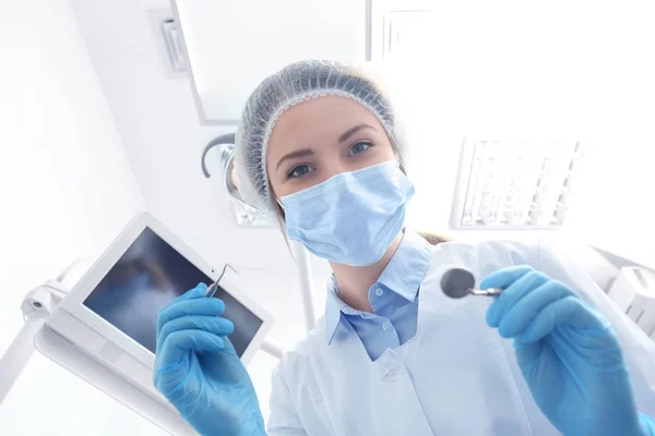 Dentist with mirror and periodontal explorer in clinic — Stock Photo, Image