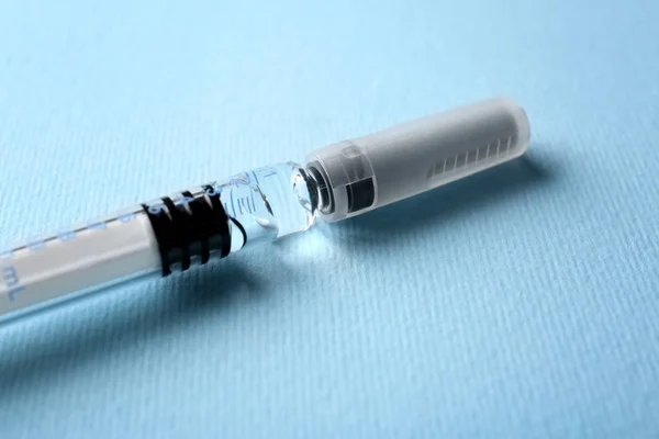 Medical syringe on blue — Stock Photo, Image