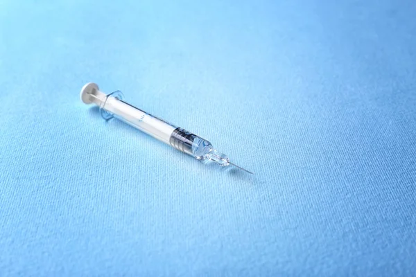 Medical syringe on blue — Stock Photo, Image