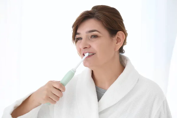 Wanita senior membersihkan gigi — Stok Foto