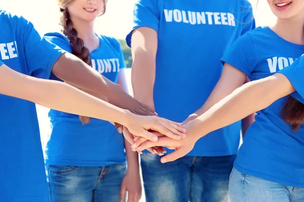 若い人たちは、一緒に屋外の手を置きます。ボランティアの概念 — ストック写真