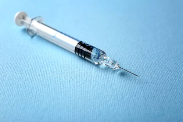 Medical syringe on blue — Stock Photo, Image