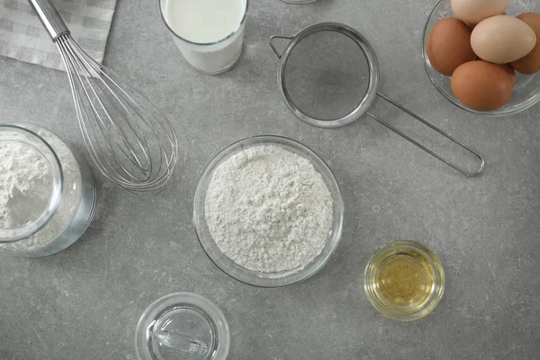 Tigela com farinha, peneira e ingredientes para a massa — Fotografia de Stock