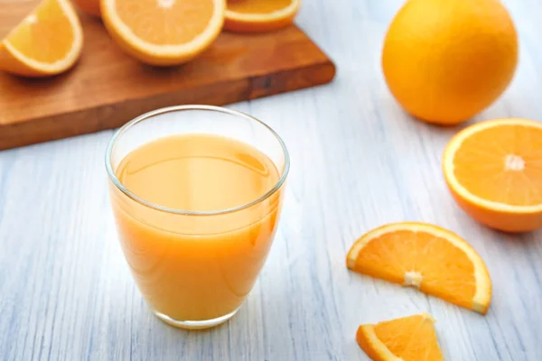 Copo de suco de laranja fresco e fatias de frutas — Fotografia de Stock