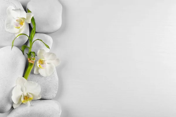Pedras de spa com flores de orquídea — Fotografia de Stock