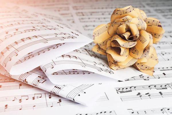 Paper rose on music notes — Stock Photo, Image