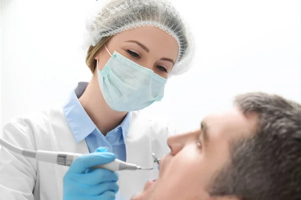Tandarts onderzoekt tanden patiënt in kliniek — Stockfoto
