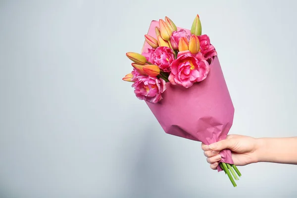 Hand holding bouquet of fresh tulips — Stock Photo, Image