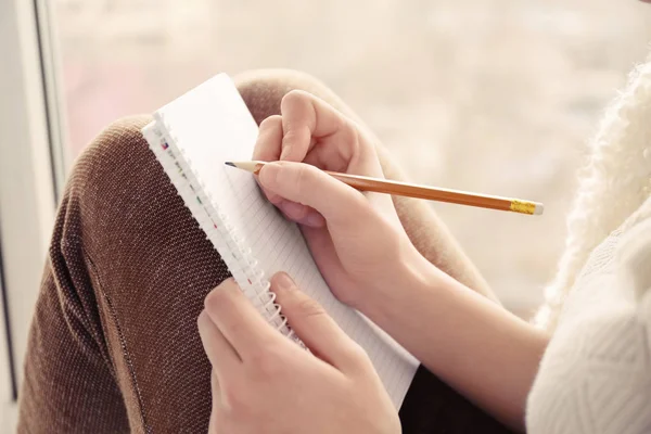 Hermosa joven escribiendo en cuaderno — Foto de Stock