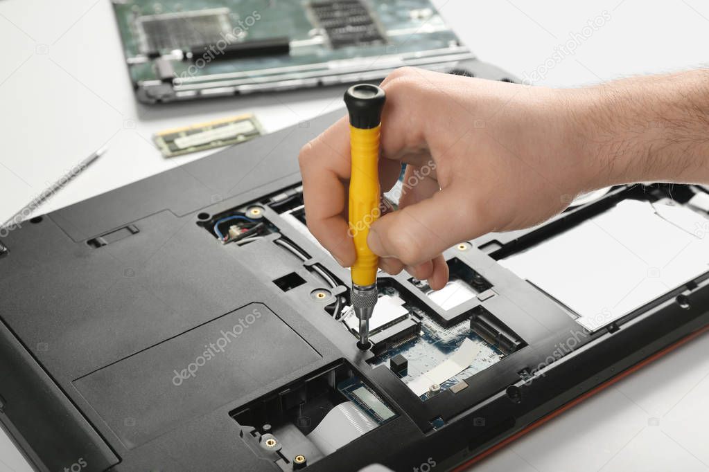 Dismantling laptop with screwdriver