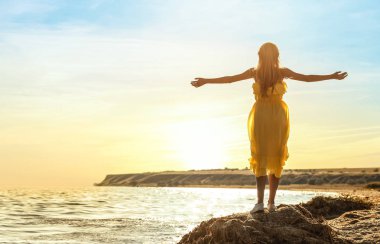 Deniz kıyısında duran genç güzel kadın