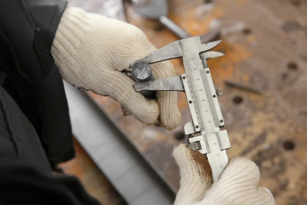 Vernier Kaliper kullanan adam