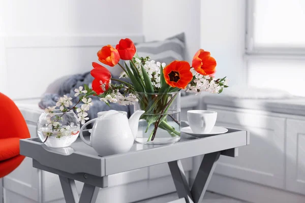 Ваза с красивыми цветами и чаем — стоковое фото
