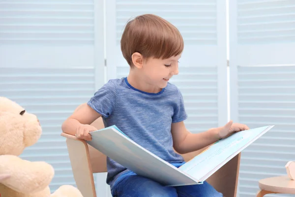 Cute little boy reading book at home — Stock Photo, Image